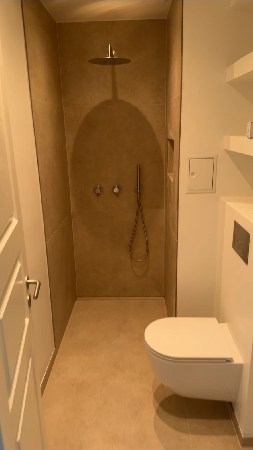 Færdigt badeværelse med indbygget brusearmatur, regnbruser og væghængt toilet